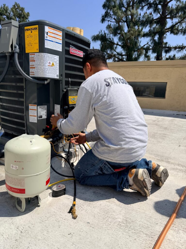 HVAC technician performing maintenance on an outdoor condenser unit in Los Angeles