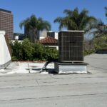 Outdoor AC condenser units on a Los Angeles rooftop under a hot summer sky