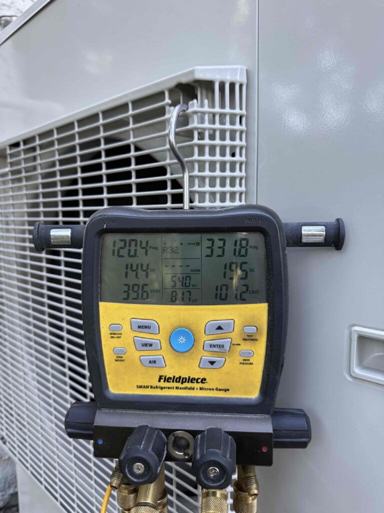HVAC technician checking system performance with a digital diagnostic gauge