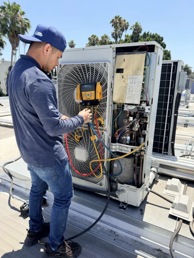 Cold Cloud technician checking refrigerant pressures on a VRF outdoor unit
