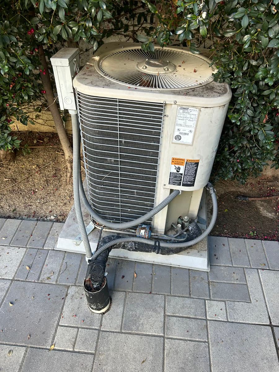 Old outdoor AC condenser before Daikin heat pump upgrade
