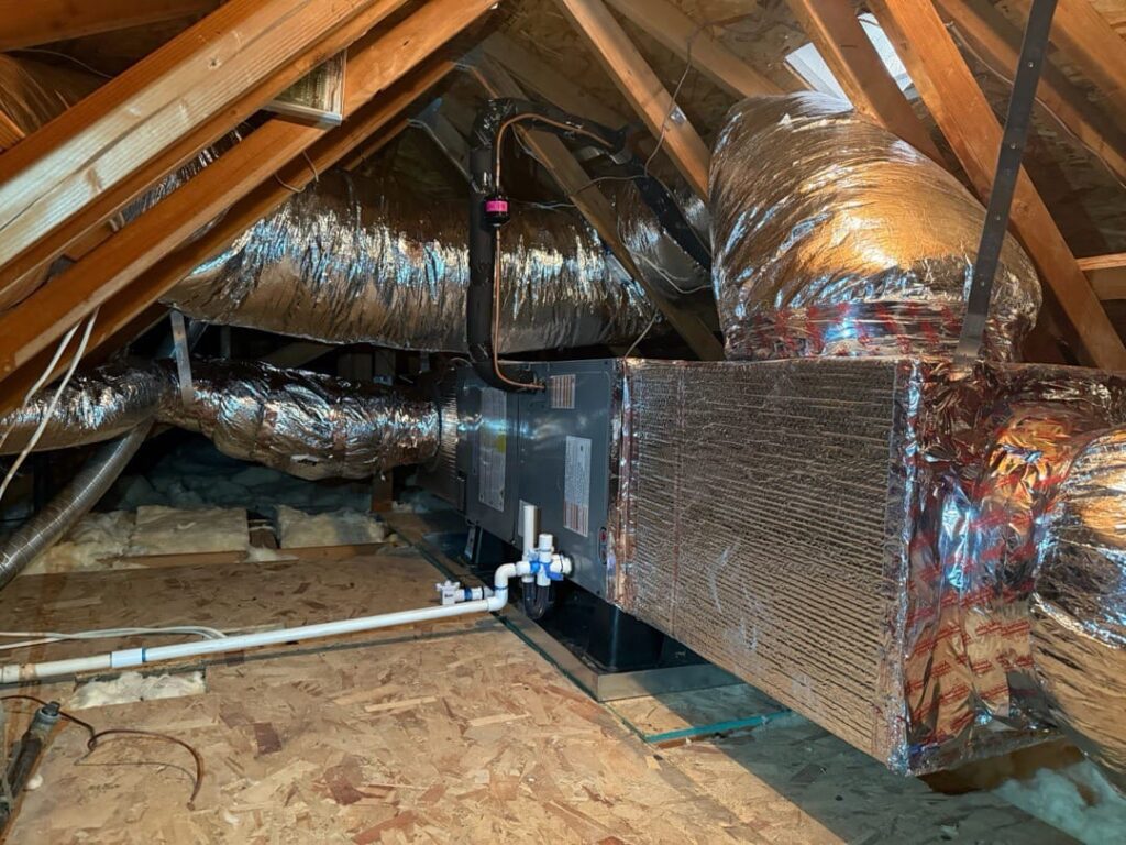 Attic insulation level is one of the four factors that change mini split sizing in LA Attic space showing insulation and ductwork inspected as part of a mini split sizing assessment