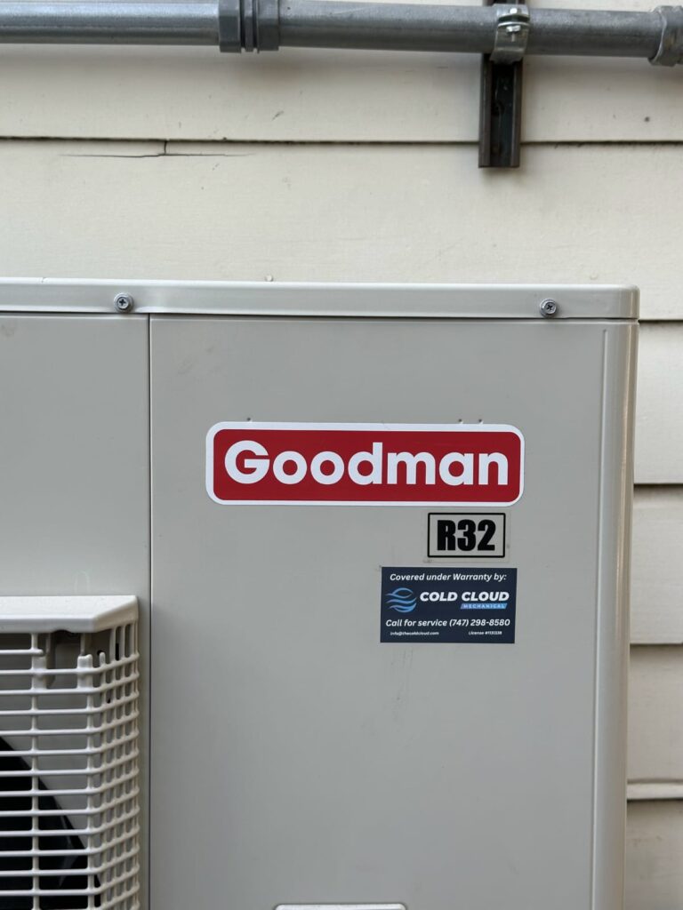 Goodman outdoor air conditioning unit with red logo panel