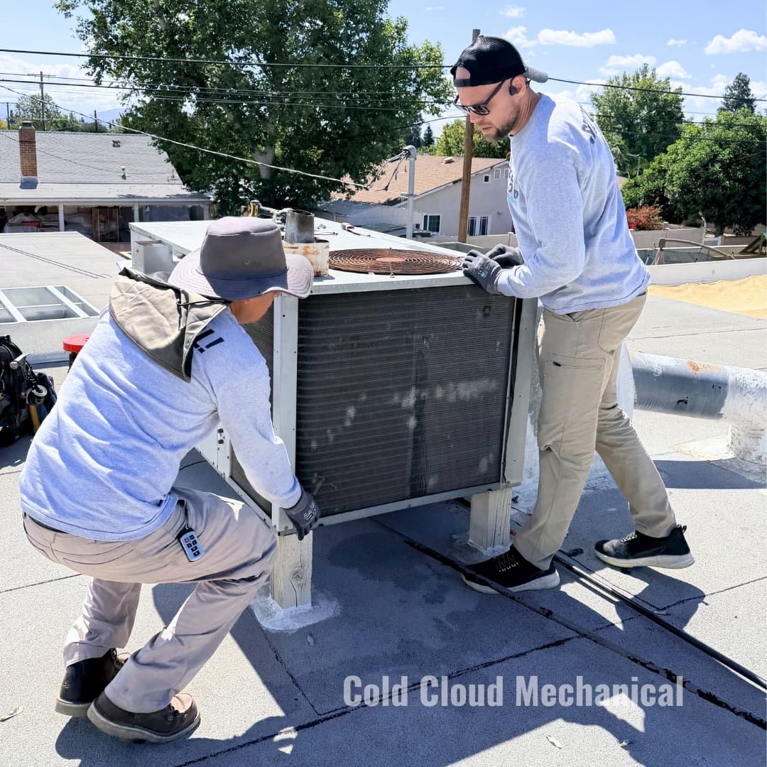 Rooftop crew installing Goodman R32 package unit