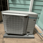 Daikin outdoor HVAC unit installed on a pad beside a home