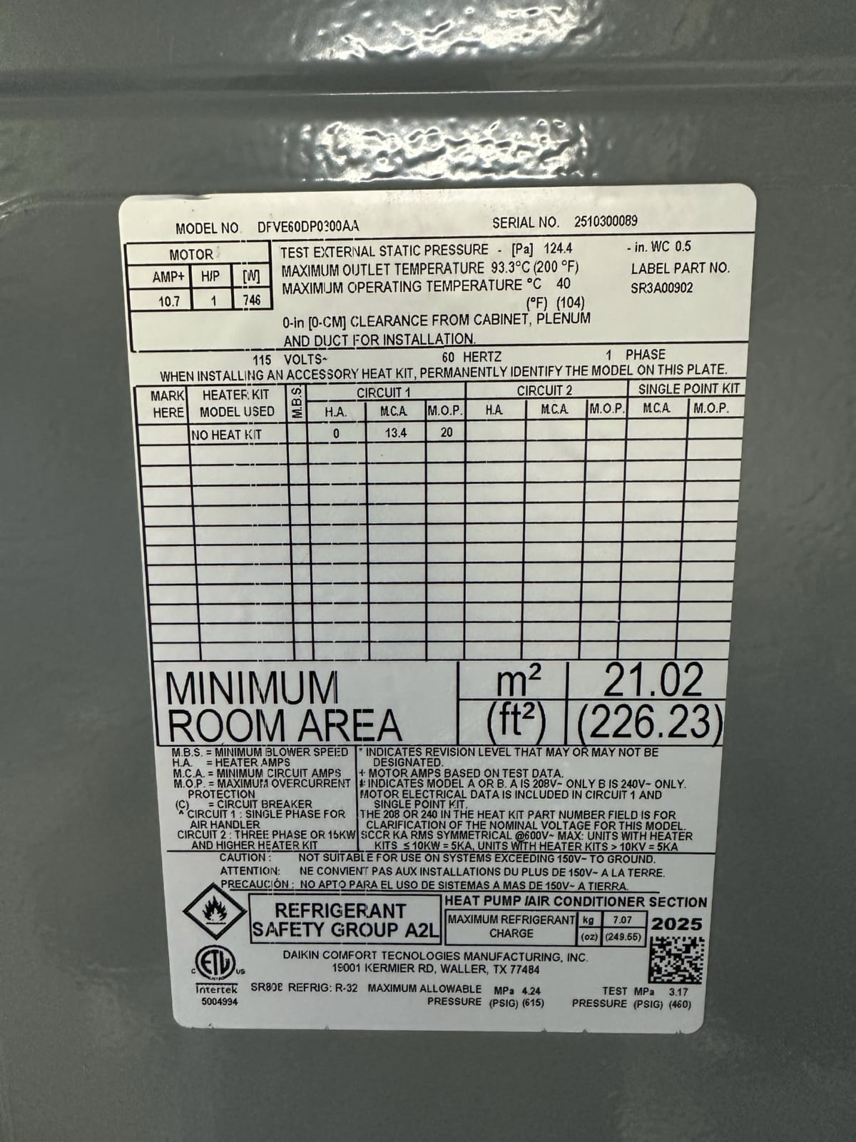 Manufacturer data plate on outdoor AC unit showing model and serial number