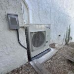 2-ton outdoor AC condenser unit on concrete pad at residential property