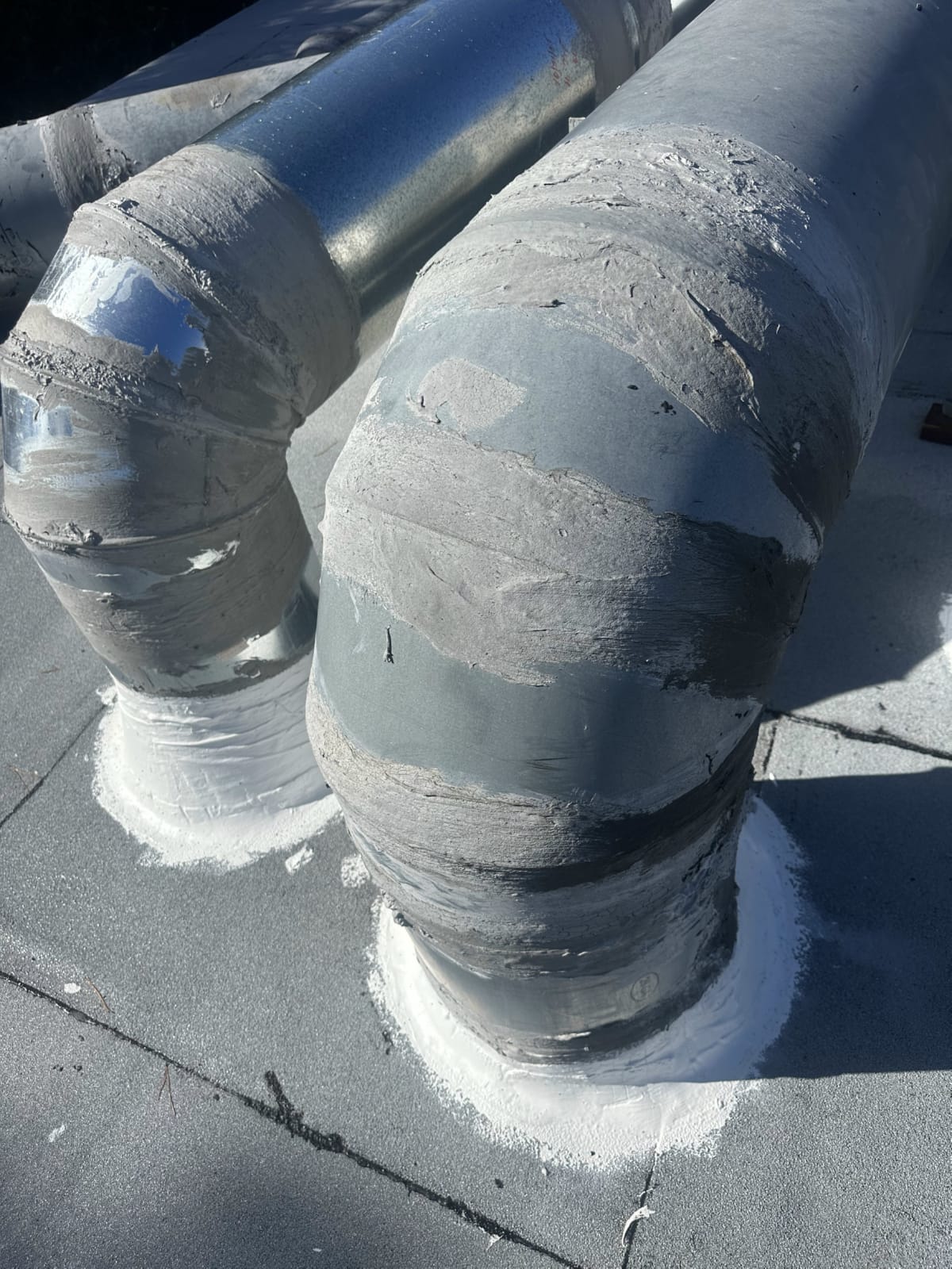 Rooftop duct insulation and sealing detail Insulated rooftop ductwork elbows sealed with mastic coating