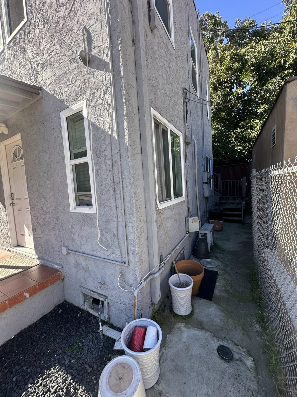 Two-story hillside home, a common dual-zone HVAC candidate Hillside two-story home in Pasadena with outdoor HVAC unit visible