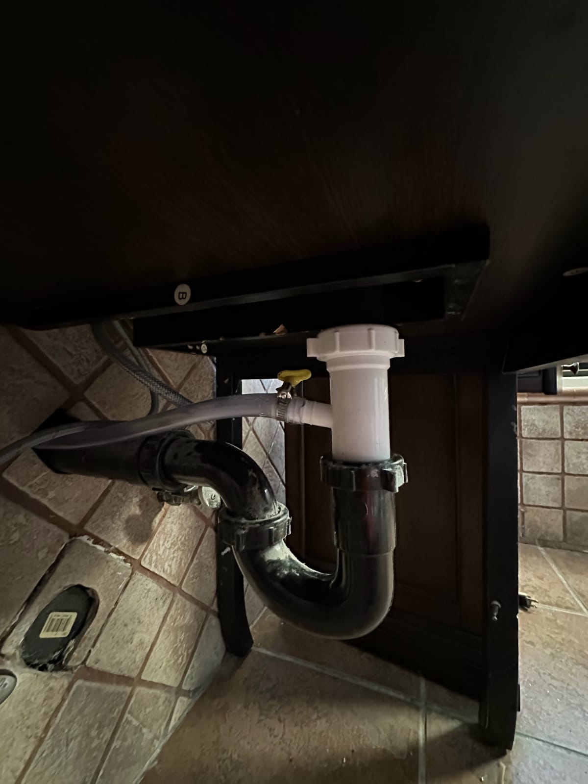 HVAC drain line and piping under a residential cabinet