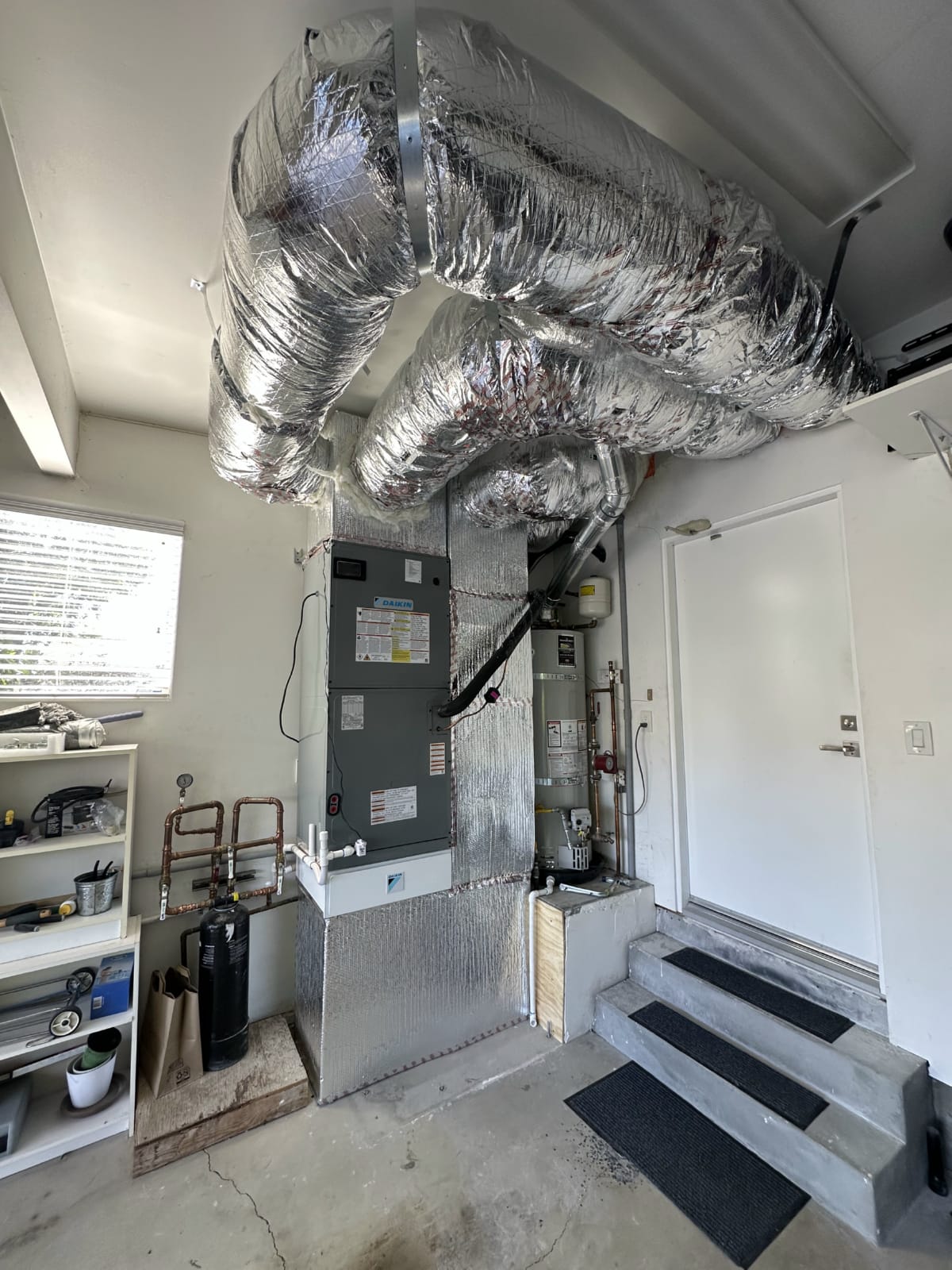 Ductwork assessment ahead of 5 ton system installation HVAC equipment closet with ductwork connections prepared for system upgrade