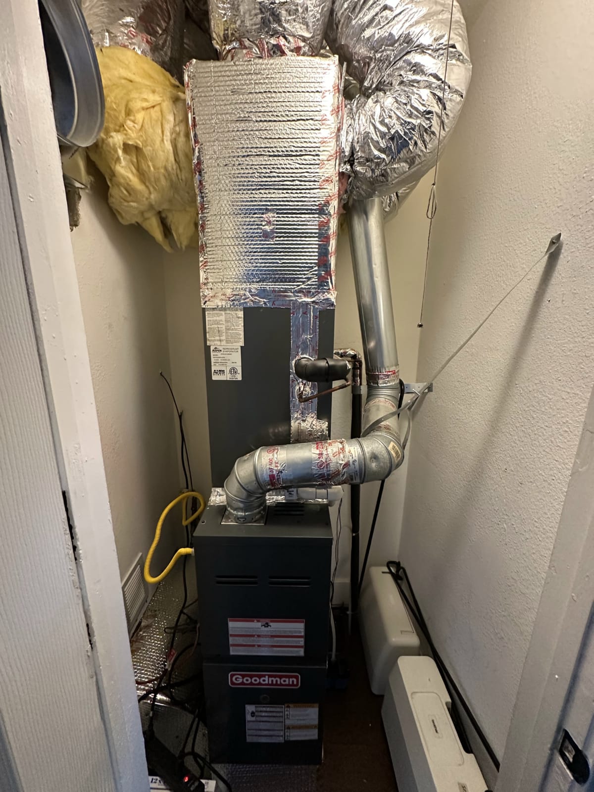 Furnace closet access for whole-house humidifier tie-in HVAC technician accessing furnace closet with ladder for humidifier installation