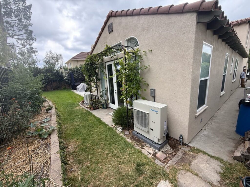 Residential outdoor AC condenser unit relocated beside house exterior