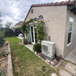 Residential outdoor AC condenser unit relocated beside house exterior