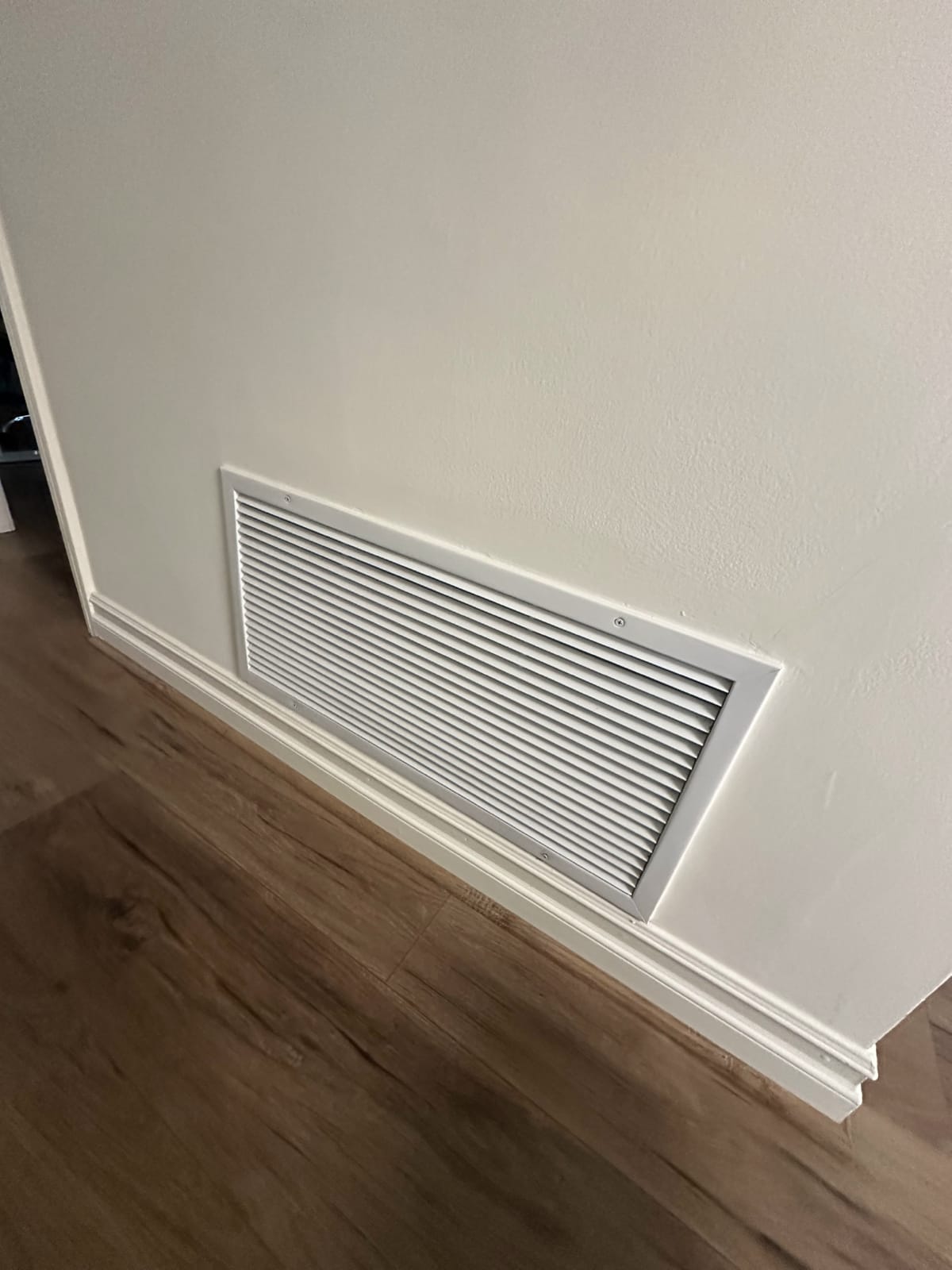 Indoor air vent assessed ahead of filtration system installation Interior supply air vent register in residential home