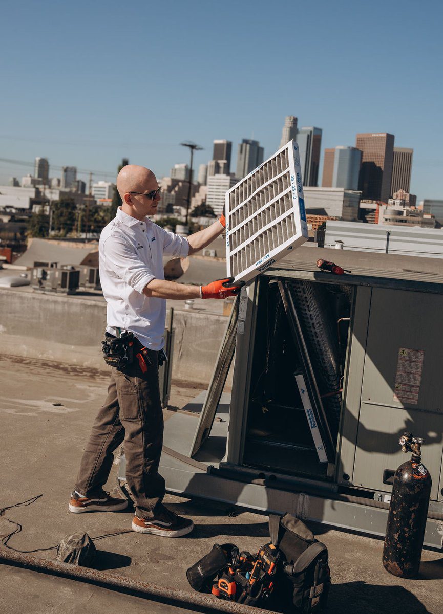 Cold Cloud technician removing a service panel on a rooftop HVAC unit in Los Angeles