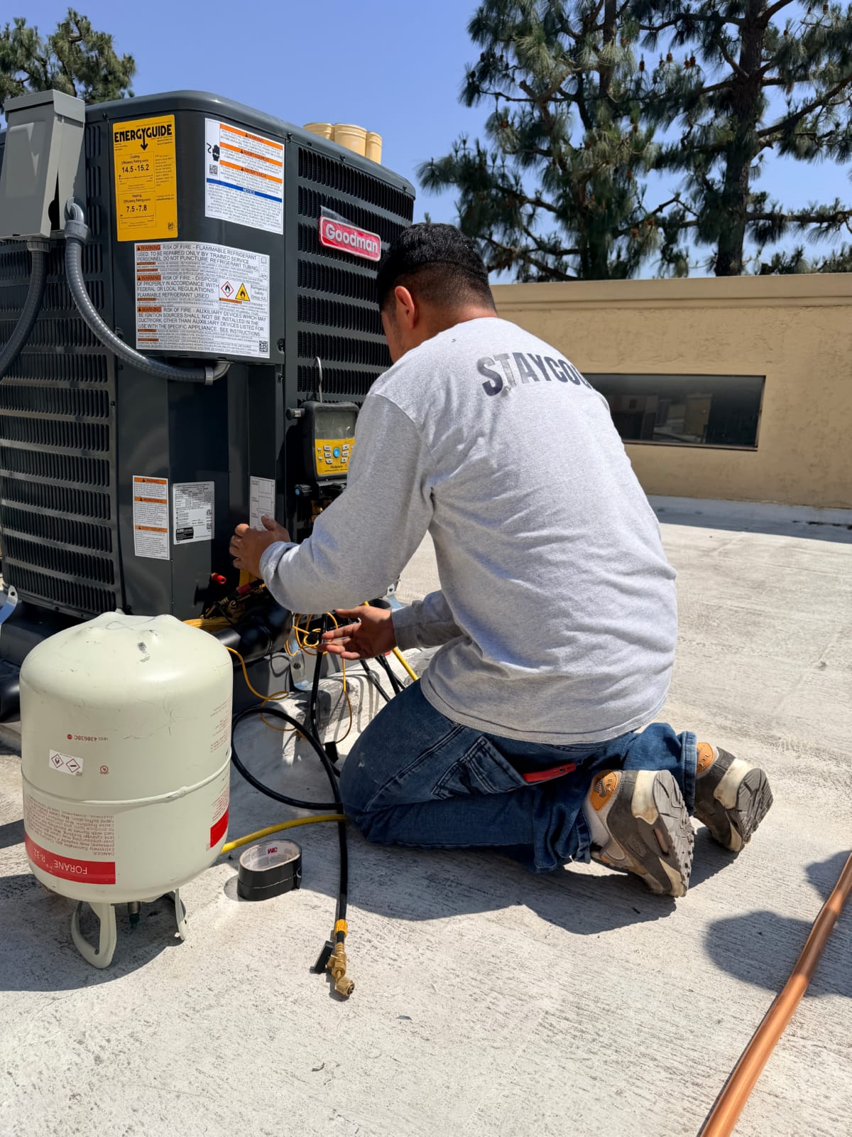 Scheduled HVAC maintenance and system assessment HVAC technician servicing rooftop condenser unit during scheduled maintenance